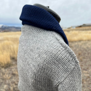 Close-up of a gray knit sleeve with a blurred background